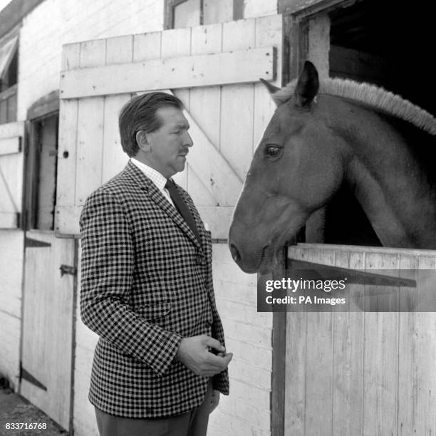 Captain James Thain, pilot in the Munich Air Disaster involving Manchester United in 1958 with one of his horses at his farm at Warfield, near...