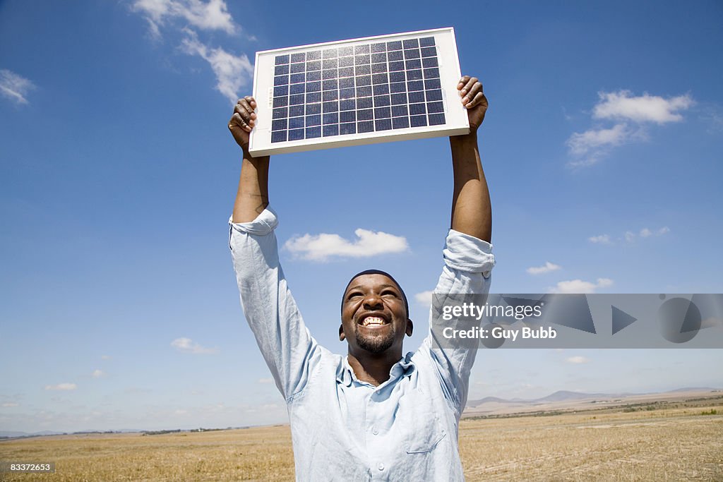 Man holding up a solar panel, Cape Town, Western Province, South Africa