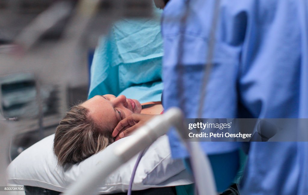 A Doula comforts a pregnant woman moments before her caesarean section.