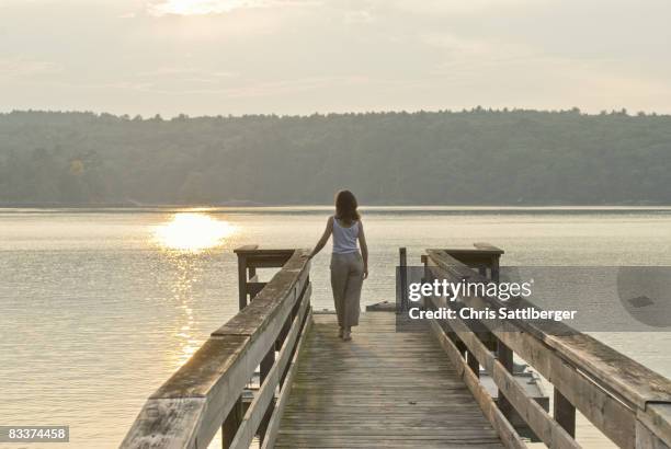 woman looking out to sea from jetty - new england women stock pictures, royalty-free photos & images