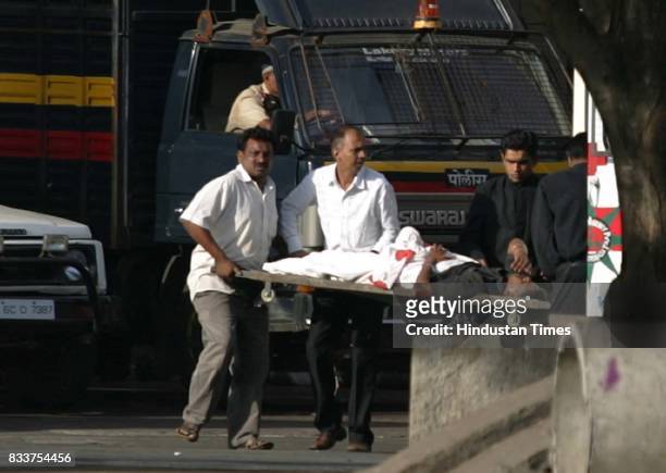 Mumbai Terror Attack: Police and fire brigade officers take an injured man who was inside the hotel, to the hospital on Thursday early morning.