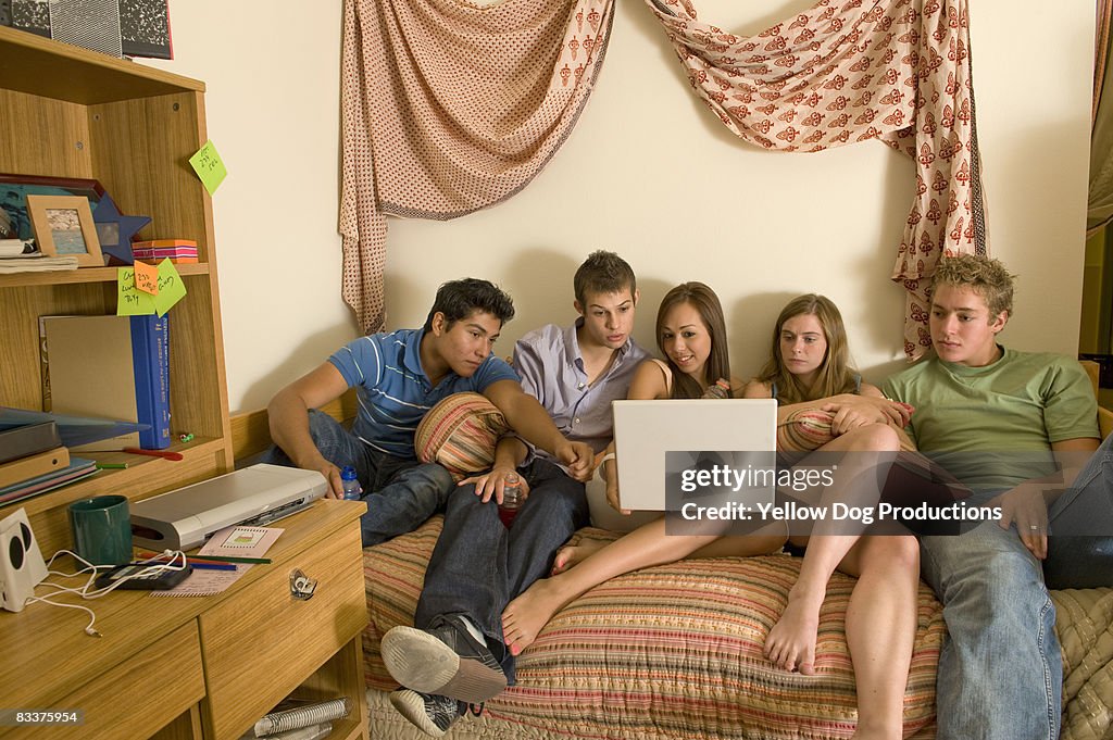 Friends watching a movie on a computer in a dorm 