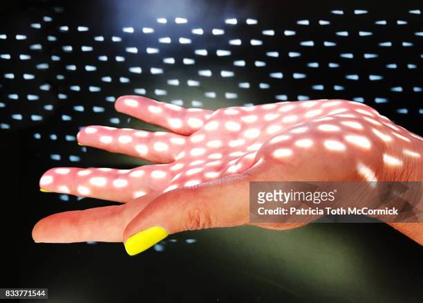 open palm touches delicate spots of light - biological immortality stock pictures, royalty-free photos & images