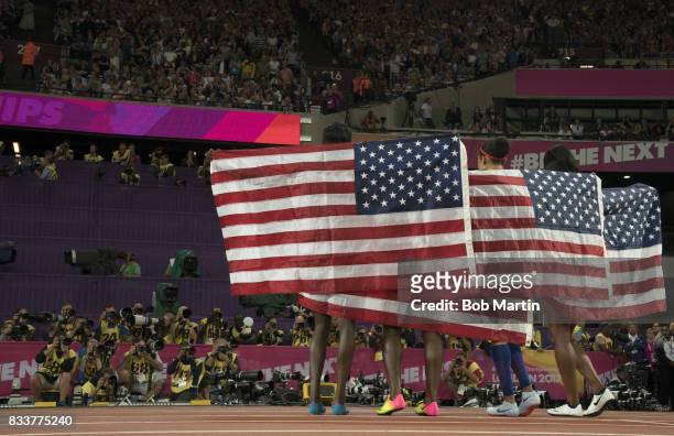 16th IAAF World Championships: Rear view of USA Team victorious, holding up USA flags after winning Women's 4X100M Final race at Olympic Stadium. USA...