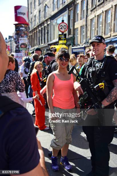 An armed police officer poses for a photograph with a Fringe-goer on the Royal Mile during the Edinburgh Festival Fringe where security has this year...