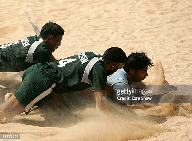 Anup Kumar of India is tackled by Pakistan during their beach kabaddi match on day five of the 2008 Asian Beach Games at Nusa Dua Beach on October...