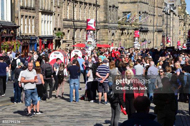 Fringe-goers and tourists enjoy the sunshine on the Royal Mile during the Edinburgh Festival Fringe with St Giles' Cathedral in the background, on...