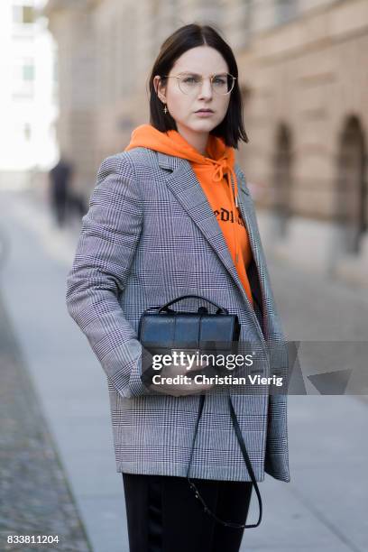 Maria Barteczko wearing orange hoodie Wasted Paris, oversized checked blazer in grey Stella McCartney, wide leg black trousers H&M, black heels...