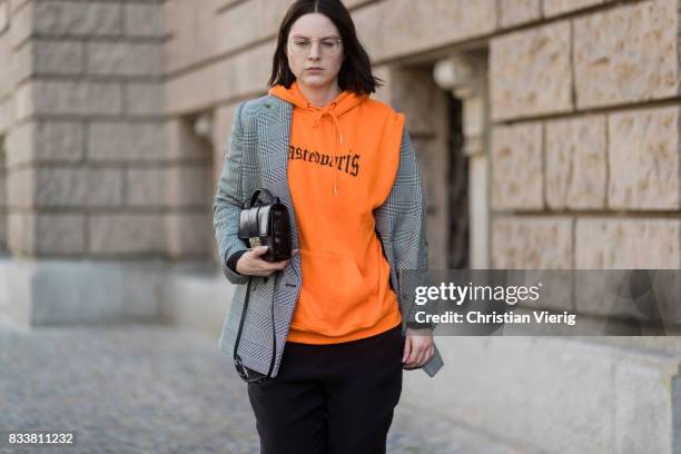 Maria Barteczko wearing orange hoodie Wasted Paris, oversized checked blazer in grey Stella McCartney, wide leg black trousers H&M, black heels...