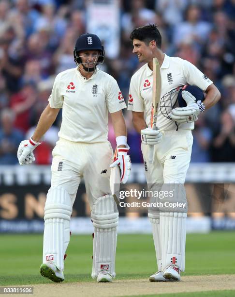 Alastair Cook of England celebrates with captain Joe Root after reaching his century during the 1st Investec Test match between England and West...