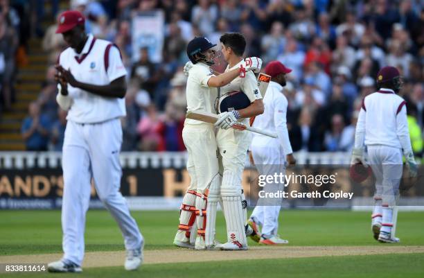 Alastair Cook of England celebrates with captain Joe Root after reaching his century during the 1st Investec Test match between England and West...