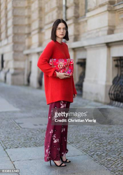 Maria Barteczko wearing red oversized wool sweater The Row, flared floral trousers Valentino, black heels Gianvito Rossi, red GG Marmont flower...