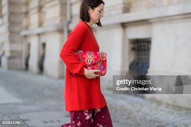 Maria Barteczko wearing red oversized wool sweater The Row, flared floral trousers Valentino, black heels Gianvito Rossi, red GG Marmont flower...