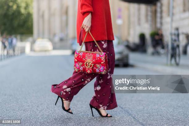 Maria Barteczko wearing red oversized wool sweater The Row, flared floral trousers Valentino, black heels Gianvito Rossi, red GG Marmont flower...