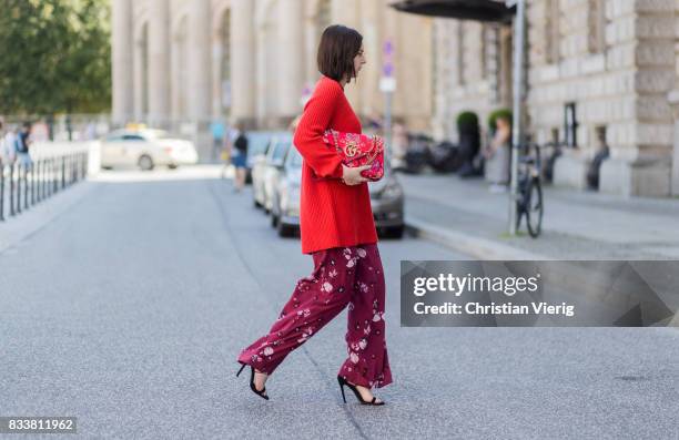 Maria Barteczko wearing red oversized wool sweater The Row, flared floral trousers Valentino, black heels Gianvito Rossi, red GG Marmont flower...