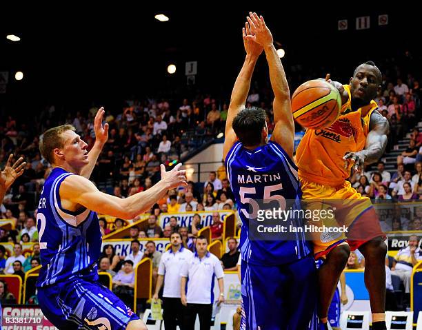 Corey Wiliams of the Crocodiles passes the ball past Damian Martin and David Gruber of the Spirit during the round six NBL match between the...