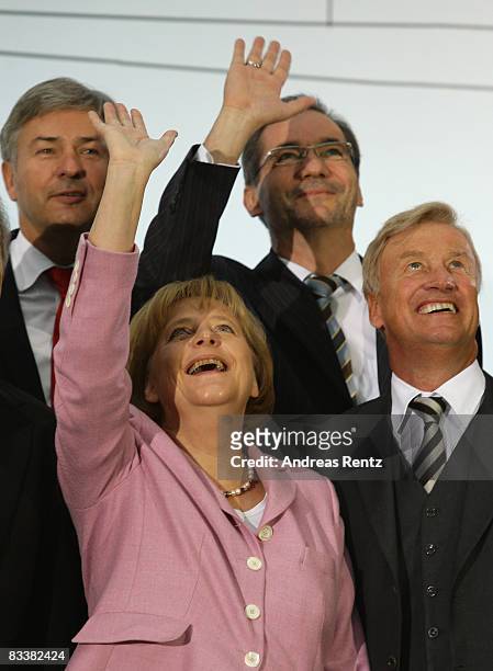 German Chancellor Angela Merkel waves as Berlin's Mayor Klaus Wowereit , Brandenburg state Governor Matthias Platzeck and Hamburg's Mayor Ole von...