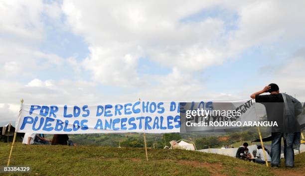 Colombian indigenous men rest next to a banner on October 22, 2008 in Santander de Quilichao, in Valle del Cauca department, during a stop on their...