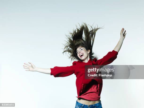 portrait of woman jumping for joy - euphorie stock-fotos und bilder