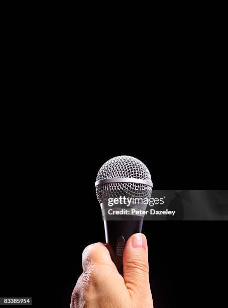 microphone and hand on black background - holding microphone stock pictures, royalty-free photos & images