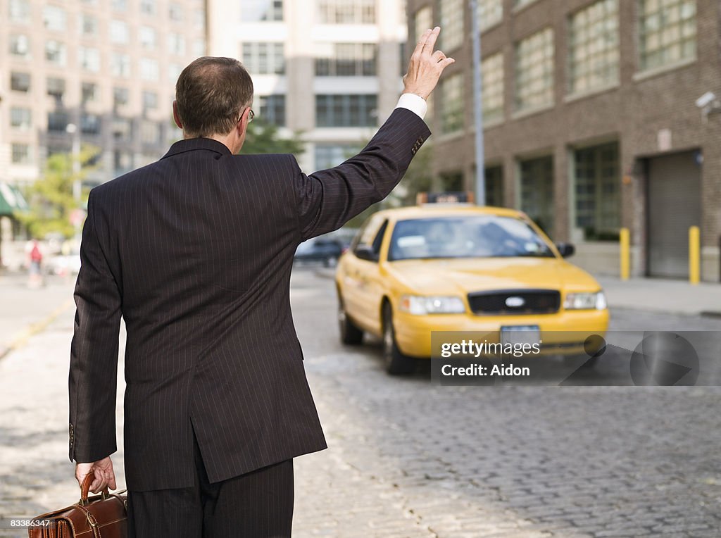 Business man hailing taxi