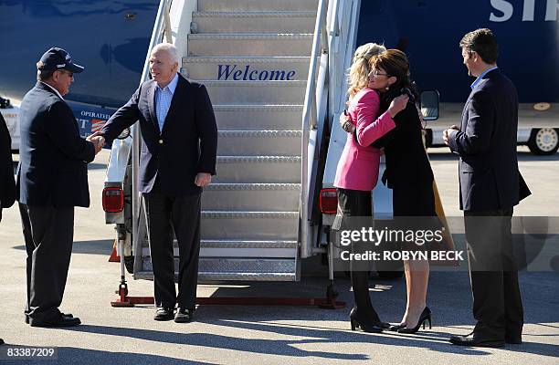 Republican presidential candidate John McCain greets a local supporter as his wife Cindy greets vice presidential running mate Sarah Palin and her...