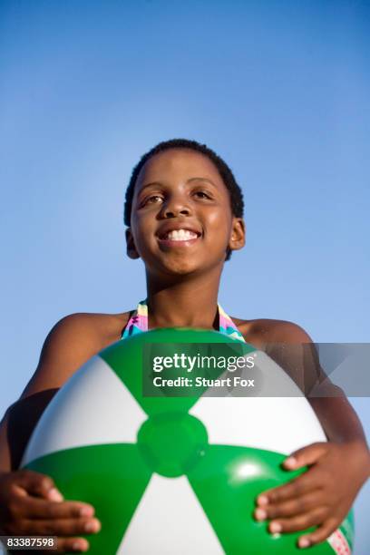 young girl smiling holding large beach ball, kwazulu natal province, south africa - large beach ball stock pictures, royalty-free photos & images