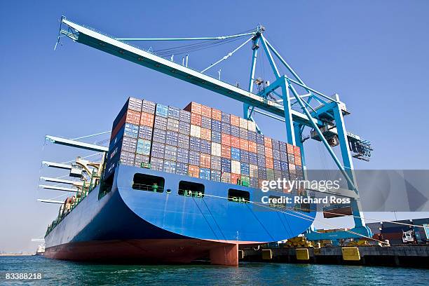 a boat carrying cargo with cranes for lifting up c - container stock-fotos und bilder