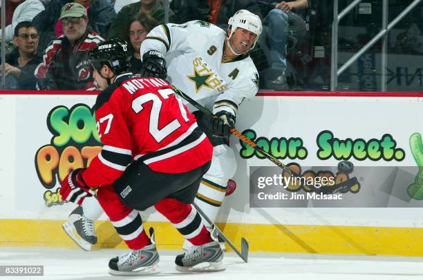 Mike Modano of the Dallas Stars flips a pass past Mike Mottau of the New Jersey Devils at the Prudential Center on October 22, 2008 in Newark, New...