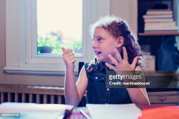 jonge expressieve roodharige meisje school huiswerk thuis doen. - counting stockfoto's en -beelden