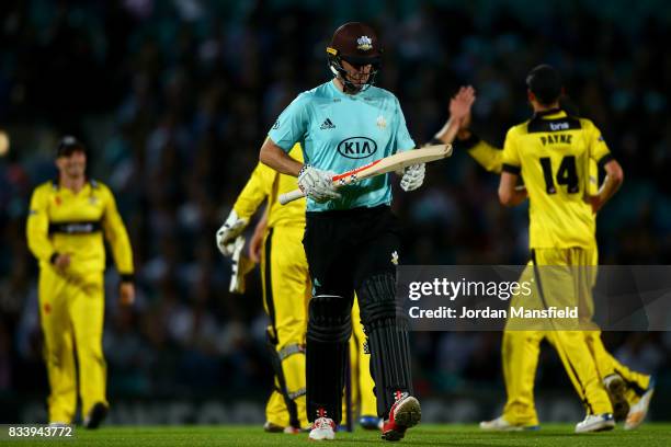 Rikki Clarke of Surrey walks off the field after being run out by Craig Miles of Gloucestershire during the NatWest T20 Blast match between Surrey...