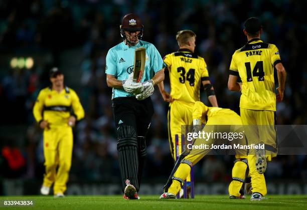 Rikki Clarke of Surrey walks off the field after being run out by Craig Miles of Gloucestershire during the NatWest T20 Blast match between Surrey...