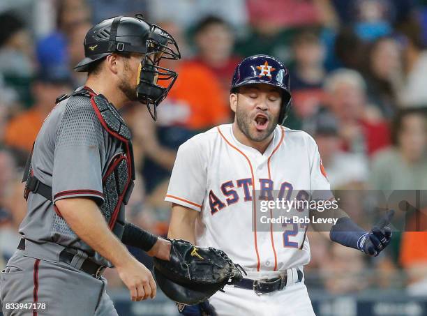 Jose Altuve of the Houston Astros reacts after catcher Jeff Mathis of the Arizona Diamondbacks tags him after first base umpire Ramon DeJesus called...