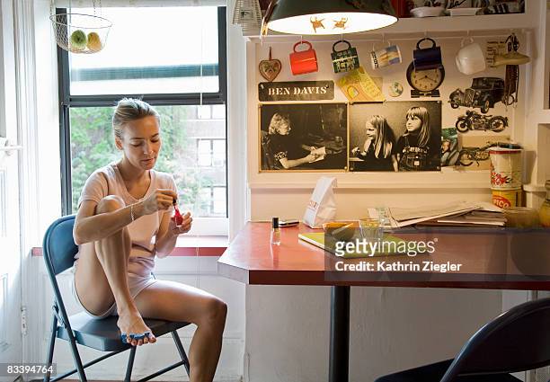 woman in kitchen, painting her nails - abbigliamento intimo foto e immagini stock