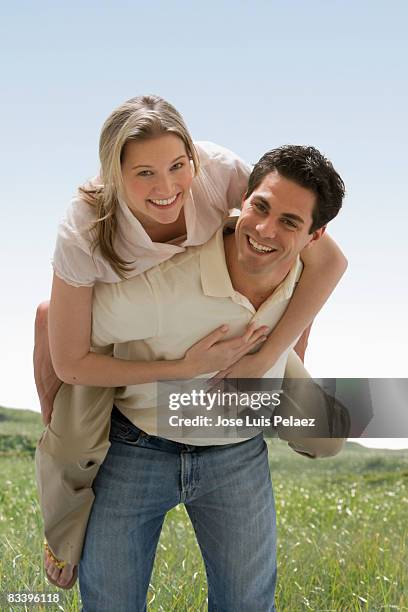 woman riding on husband's back - piggyback stock pictures, royalty-free photos & images