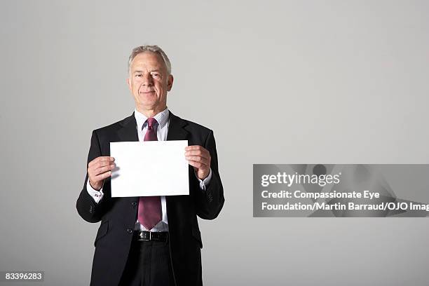 man holding a blank piece of paper - holding paper fotografías e imágenes de stock