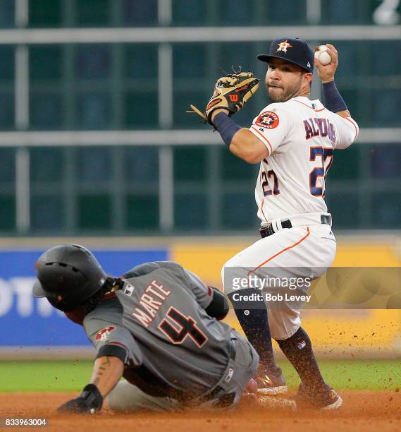 Jose Altuve of the Houston Astros throws over Ketel Marte of the Arizona Diamondbacks to complete a double play in the sixth inning at Minute Maid...
