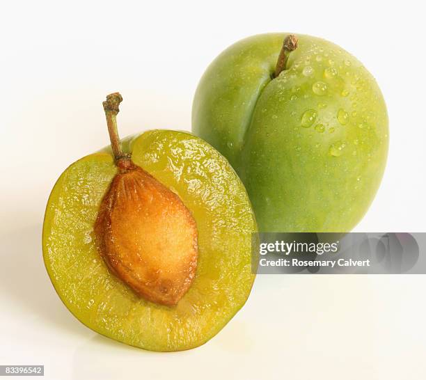 half a greengage with whole greengage. - greengage stock pictures, royalty-free photos & images