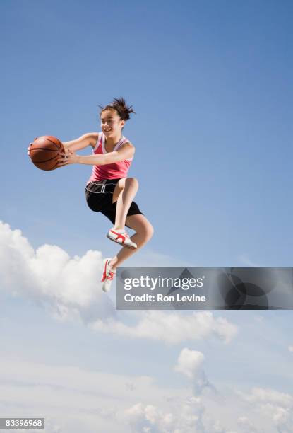 girl, airborne, with basketball - teenage girl basketball photos et images de collection