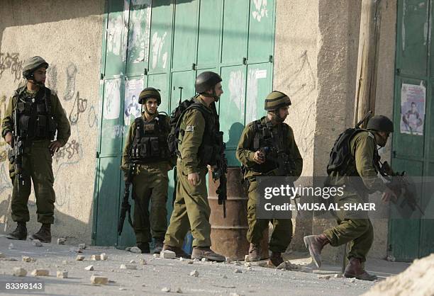Stones litter the ground as Israeli soldiers carry out a military operation in the village of Tuqua in the West Bank near Bethlehem on October 23 to...