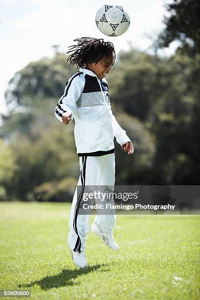 boy jumping to head butt soccer ball, zoolake park, johannesburg, gauteng, south africa - boy tracksuit stock pictures, royalty-free photos & images