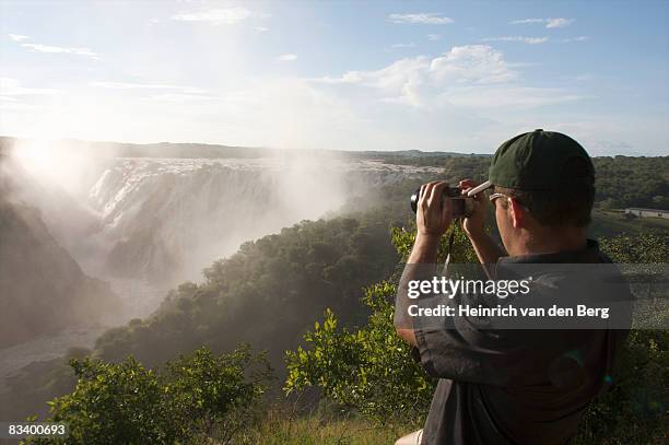 man admiring falls, ruacana falls, kunene river, kaokoland, namibia - freek van den bergh stock pictures, royalty-free photos & images