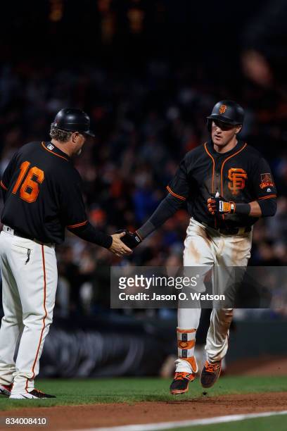Ryder Jones of the San Francisco Giants is congratulated by third base coach Phil Nevin after hitting a two run home run against the Chicago Cubs...
