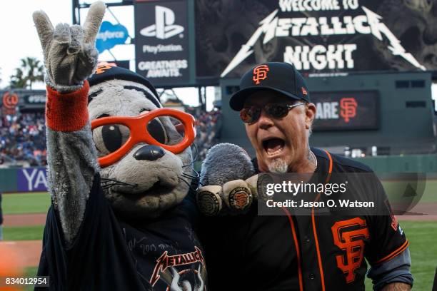 Recording artist James Hetfield of the rock band Metallica stands on the field with San Francisco Giants mascot Lou Seal before the game against the...