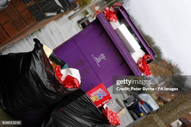 Rubbish bin in Liverpool overflows with wrapping paper and packaging from opened Christmas presents.