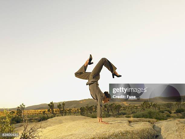 businesswoman in the desert doing a handspring - businesswoman handstand stock-fotos und bilder