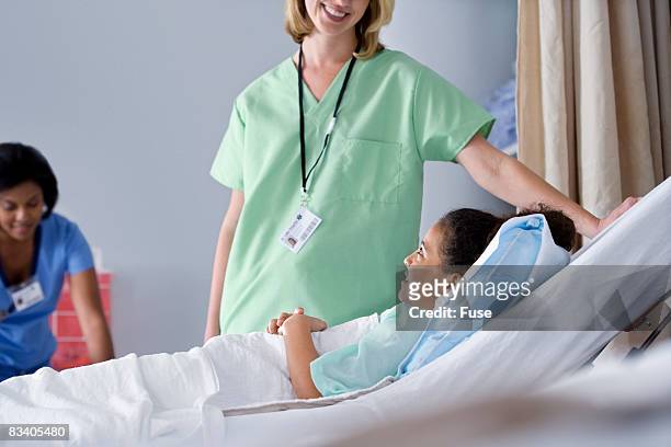 nurse assisting patient in bed - preadolescent kind 個照片及圖片檔