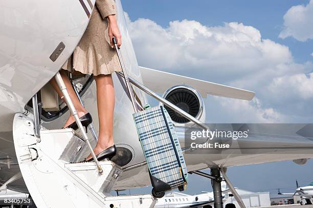 businesswoman boarding plane - mobile on plane stock-fotos und bilder