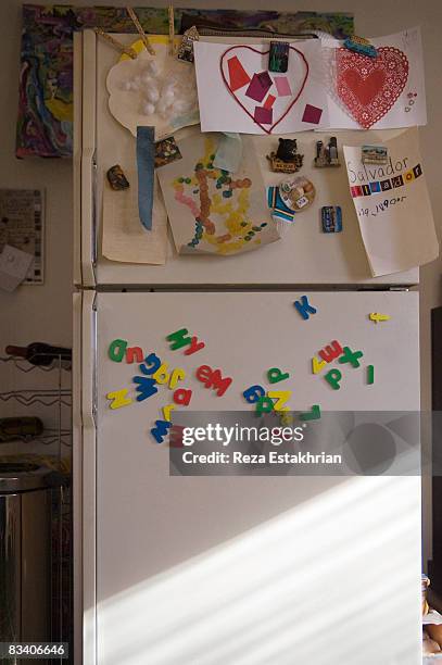 refrigerator door with child's school art projects - magnete foto e immagini stock