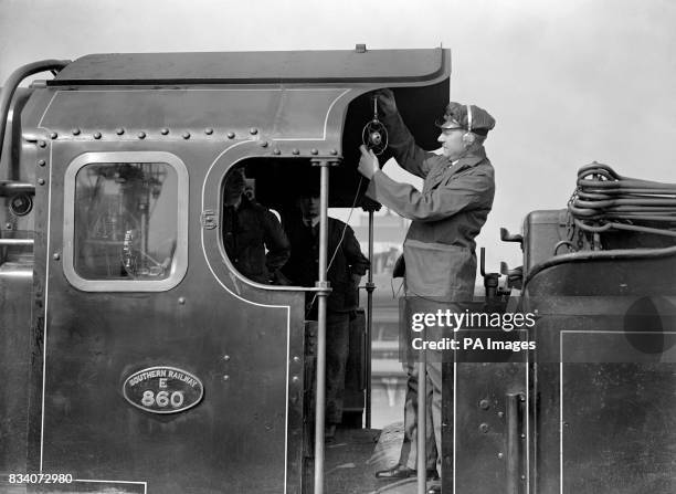 Reginald Foort travelling on the foot plate where he is seen adjusting the microphone, in an endeavour to secure local colour and time sound of which...